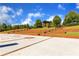 A multi-tiered outdoor amphitheater with manicured grass and brick accents under a bright blue sky with scattered clouds at 4238 Hamilton Mill Rd, Buford, GA 30519