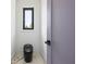 Modern half bathroom featuring marble floors and a sleek, black toilet under a window at 4238 Hamilton Mill Rd, Buford, GA 30519