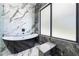 Modern bathroom with freestanding tub, marble wall tiles, and a window for natural light at 4238 Hamilton Mill Rd, Buford, GA 30519