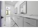 This bathroom features a double vanity, marble floors, white cabinets, and modern fixtures at 4238 Hamilton Mill Rd, Buford, GA 30519
