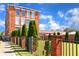 Brick building featuring a sign for Tannery Row with manicured lawn and wrought iron fence at 4238 Hamilton Mill Rd, Buford, GA 30519