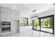 Bright kitchen with modern appliances, white cabinetry, and sliding glass doors to the backyard at 4238 Hamilton Mill Rd, Buford, GA 30519