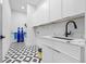 Well-lit laundry room featuring patterned floors, modern cabinets, and a sink with an elegant matte black faucet at 4238 Hamilton Mill Rd, Buford, GA 30519