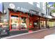 Restaurant exterior with a striking black and red facade, inviting windows, and sidewalk seating at 4238 Hamilton Mill Rd, Buford, GA 30519