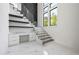 Modern staircase with sleek design, glass railings, floating stairs, and a built-in desk area, offering a contemporary feel at 4238 Hamilton Mill Rd, Buford, GA 30519