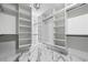 Large walk-in closet featuring custom white shelving, cabinets, and sleek marble flooring at 4238 Hamilton Mill Rd, Buford, GA 30519