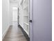 Spacious walk-in closet with custom shelving and gray wood floors leading to another room at 4238 Hamilton Mill Rd, Buford, GA 30519
