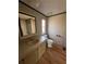 Bathroom features a sink, toilet, mirror and window with linoleum flooring and striped wallpaper at 166 James Drive, Hampton, GA 30228