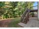 Backyard stairs from deck down to a stone patio and lawn at 625 Jefferson Pl, Cumming, GA 30040
