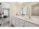 Well-lit bathroom features double sinks, white cabinetry, and an adjoining bedroom for a seamless transition at 625 Jefferson Pl, Cumming, GA 30040