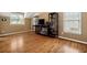 A sunlit bedroom with rich hardwood floors and built-in dark wood shelving units at 625 Jefferson Pl, Cumming, GA 30040