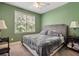 Relaxing bedroom with green walls, large window and a plush queen-sized bed at 625 Jefferson Pl, Cumming, GA 30040