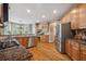 Kitchen featuring stainless steel appliances, wooden cabinets, and granite countertops at 625 Jefferson Pl, Cumming, GA 30040