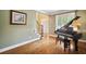 Bright living room featuring a piano, hardwood floors, and large windows at 625 Jefferson Pl, Cumming, GA 30040