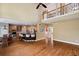 Open living space showcasing hardwood floors, a breakfast bar, and second story balcony at 625 Jefferson Pl, Cumming, GA 30040