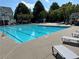 Community pool area surrounded by lounge chairs and lush landscaping at 625 Jefferson Pl, Cumming, GA 30040