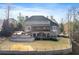 Large brick home with a well-manicured lawn, patio, and stone fire pit in the backyard at 1355 Cashiers Way, Roswell, GA 30075