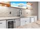 Close-up of wet bar area with beverage fridge, stone counter, brick wall, and wood floating shelves at 1355 Cashiers Way, Roswell, GA 30075