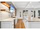 Basement bar area with white cabinets, marble countertops, beverage fridge, and wood floating shelves at 1355 Cashiers Way, Roswell, GA 30075