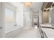 Bright bathroom features a soaking tub, separate shower, and double vanity with marble countertops at 1355 Cashiers Way, Roswell, GA 30075