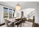 Elegant dining room with a chandelier, large windows, and wood floors, near the staircase at 1355 Cashiers Way, Roswell, GA 30075