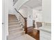 Foyer featuring a carpeted staircase and an arched doorway leading to the kitchen at 1355 Cashiers Way, Roswell, GA 30075