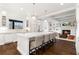 Open-concept kitchen with a large island, bar seating, and stainless steel appliances, open to a cozy living room at 1355 Cashiers Way, Roswell, GA 30075