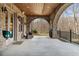 Covered brick patio featuring brick arches, concrete floor, and a peaceful backyard view at 1355 Cashiers Way, Roswell, GA 30075