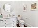 Well-lit powder room with a round mirror and decorative wall art at 1355 Cashiers Way, Roswell, GA 30075