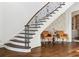 Elegant staircase with dark wood treads and decorative iron railing, accented by floral wallpaper at 1355 Cashiers Way, Roswell, GA 30075