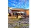 A sun-lit backyard featuring a small outdoor seating area, a well-maintained lawn, and a brown home exterior at 3476 Harvest Ridge Ln, Buford, GA 30519