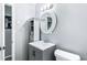 Bright bathroom features a white sink vanity, round mirror, and light gray walls at 1646 Flicker Rd, Jonesboro, GA 30238