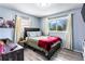 Bedroom featuring stylish decor, a cozy bed, wood-look floors, and natural light from two windows at 1646 Flicker Rd, Jonesboro, GA 30238