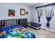 Cozy bedroom with colorful decor, gray laminate flooring, and a bright window at 1646 Flicker Rd, Jonesboro, GA 30238