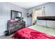 Cozy bedroom featuring a stylish dresser, a bed with a red blanket, and a decorative mirror at 1646 Flicker Rd, Jonesboro, GA 30238