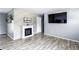 Living room features stone accent wall with a fireplace, tv on the wall, and modern wood look floors at 1646 Flicker Rd, Jonesboro, GA 30238