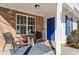 Inviting front porch with seating, a brick accent wall and a bright blue front door at 392 Fourth St, Forest Park, GA 30297
