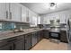 Modern kitchen with stainless steel appliances, sleek gray cabinets, and tiled backsplash at 392 Fourth St, Forest Park, GA 30297