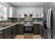 Well-lit kitchen featuring stainless steel appliances, granite countertops, and mosaic backsplash at 392 Fourth St, Forest Park, GA 30297