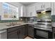 Modern kitchen with stainless steel range, gray cabinets, and mosaic tile backsplash at 392 Fourth St, Forest Park, GA 30297