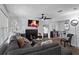 Cozy living room with fireplace, gray sofa, ceiling fan, and seamless access to the dining area at 392 Fourth St, Forest Park, GA 30297