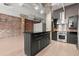 Modern kitchen with a black island, stainless steel appliances, exposed brick, and sleek black cabinetry at 434 Marietta Nw St # 301, Atlanta, GA 30313
