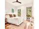 Bright bedroom with hardwood floors, a ceiling fan, and a door leading to a balcony overlooking the trees at 1250 Lupo Loop, Palmetto, GA 30268