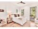 Bright bedroom with hardwood floors, a ceiling fan, and a door leading to a balcony overlooking the trees at 1250 Lupo Loop, Palmetto, GA 30268