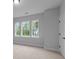A serene bedroom showcasing three bright windows overlooking a lush landscape and a classic white door at 4830 Briscoe Dr, Cumming, GA 30028