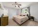 This bedroom includes a ceiling fan, large window, and warm paint and carpet tones at 4883 Rock Haven Dr, Lilburn, GA 30047
