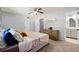 This bedroom provides a ceiling fan, access to an ensuite, and neutral paint and carpet at 4883 Rock Haven Dr, Lilburn, GA 30047