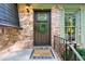 Close-up of the inviting front door with brick facade, green shutters and a welcoming wreath at 4883 Rock Haven Dr, Lilburn, GA 30047