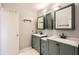 Well-lit bathroom with double vanities featuring marble countertops, sage cabinets, and modern fixtures at 6520 Roswell Rd # 79, Sandy Springs, GA 30328