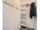 Organized closet with white shelving and convenient coat hooks for efficient storage at 6520 Roswell Rd # 79, Sandy Springs, GA 30328